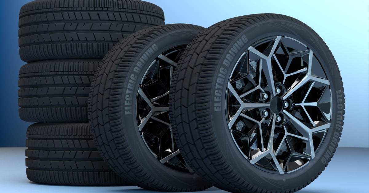 A set of five tires sitting against a blue backdrop. Two of them are upright and have "electric driving" printed on them.
