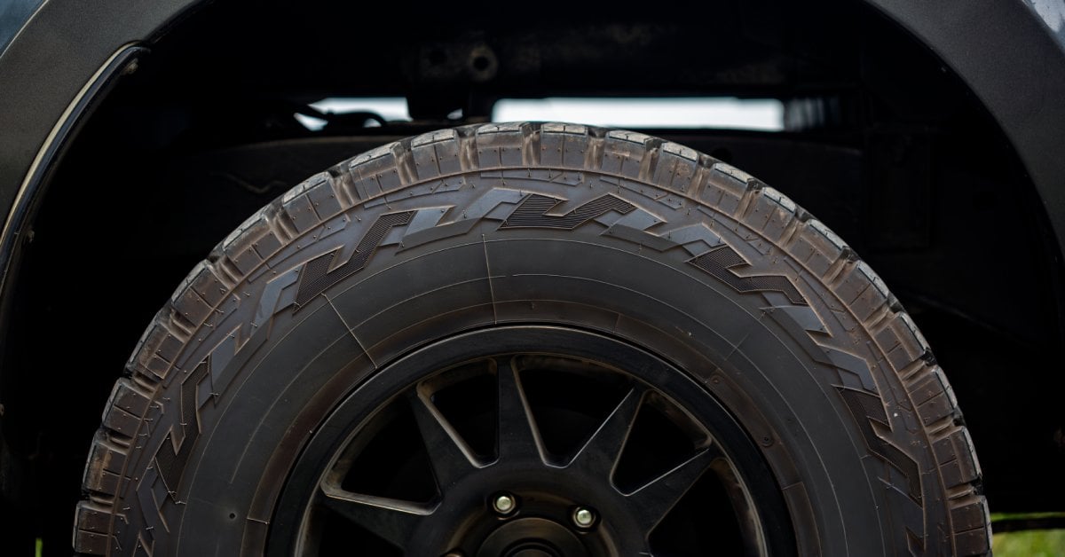 A close-up of a tire installed on a pickup truck. The tire is quite thick and has a design on the side of it.