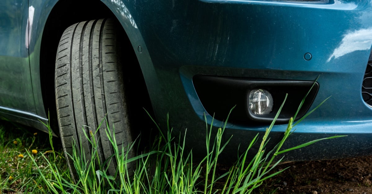 The front wheel is turned outward exposing the brake pads and rotor, positioned for an easy visual inspection of brake components.