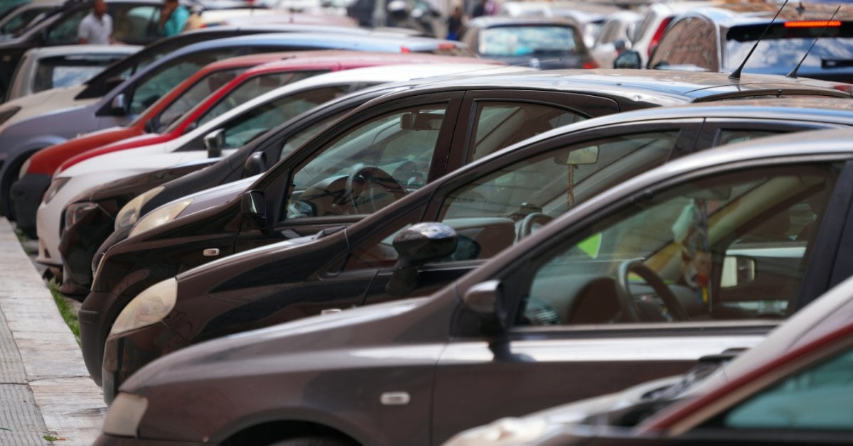 A Simple Guide to Curb Rash and How to Repair It A row of cars parked along a busy urban street lined with buildings and pedestrians in the background.