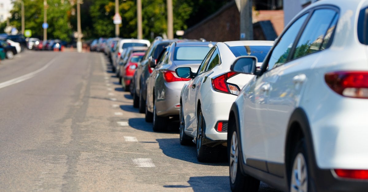 A Simple Guide to Curb Rash and How to Repair It A row of cars parallel parked along a sunny urban street, the kind of tight spot where curb rash can easily happen.